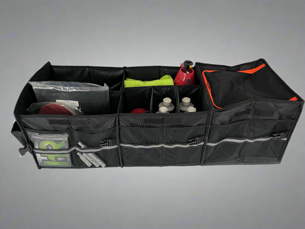 Black car trunk organizer with various items on a gray background